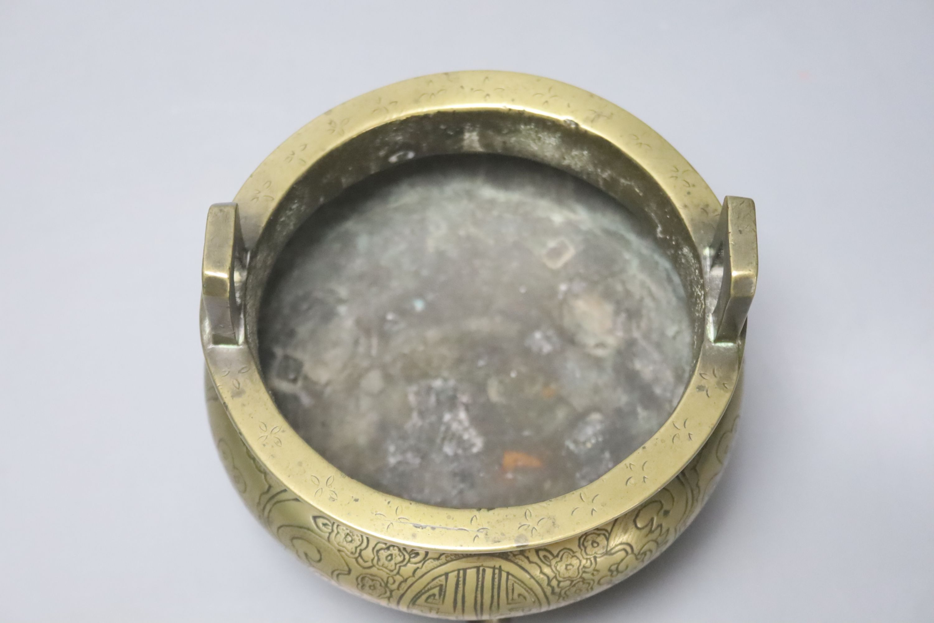 A 19th century Chinese engraved bronze tripod censer, Xuande mark to base, height 11cm